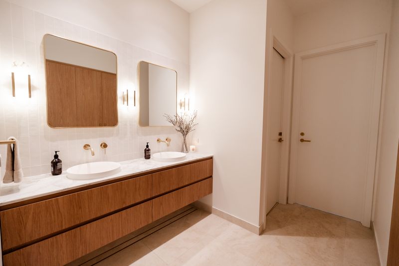 Ensuite with a floating timber vanity and doorways through to the rest of the home