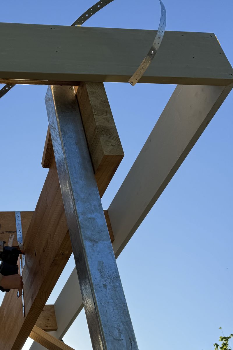 A structural steel post and beam set against a clear sky
